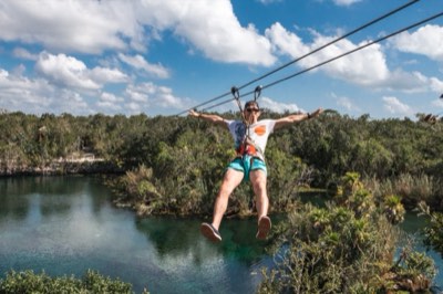Zip line ride out over the water of an open cenote