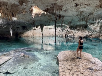 Guest admiring the vaulted ceiling of a cave cenote