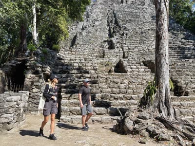 Kat guiding a guest at the base of a Coba pyramid