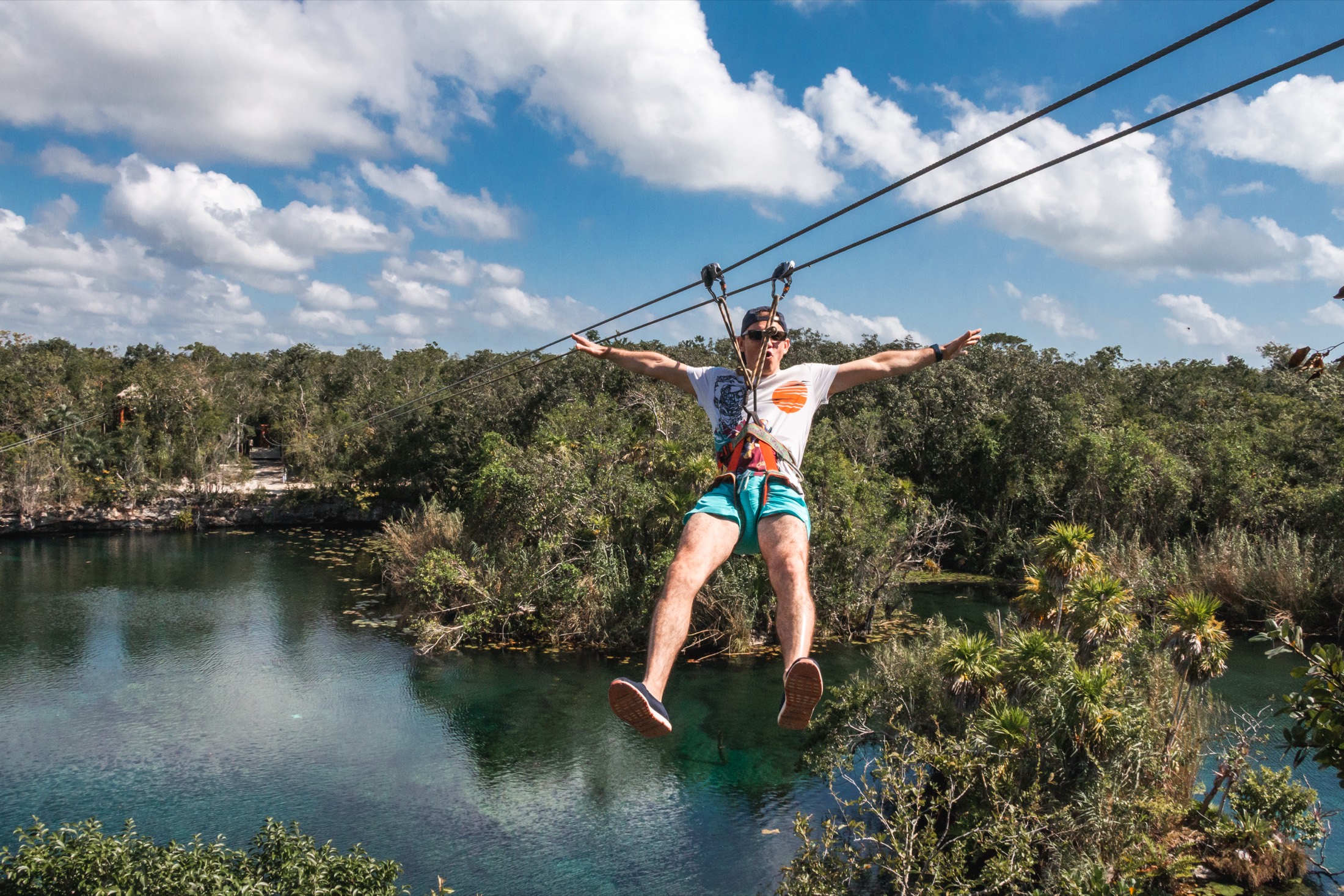 Zip line ride out over the water of an open cenote