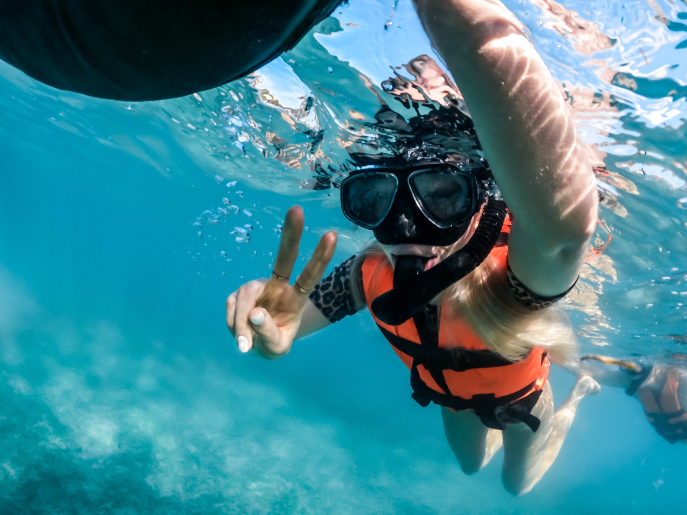 Snorkellers swimming out from the beach into the open bay