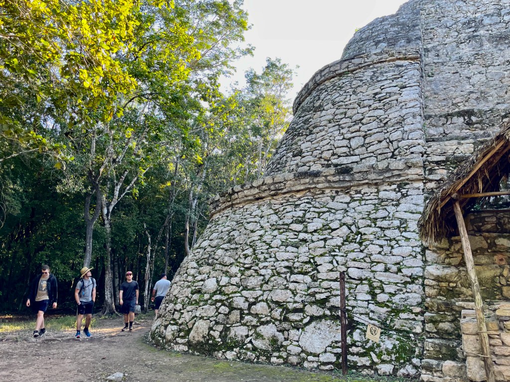 Walking past a stone temple at the Coba ruins