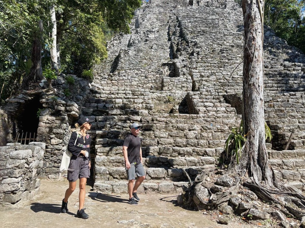 Kat guiding a guest at the base of a Coba pyramid